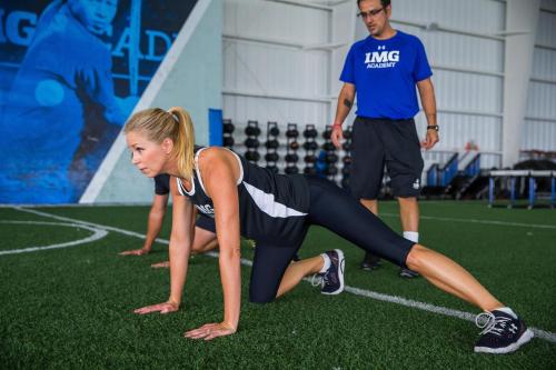 a woman doing a push up on a soccer field at Legacy Hotel at IMG Academy in Bradenton