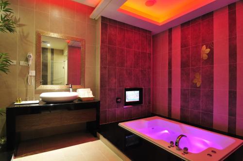 a bathroom with a pink tub and a sink at One + One Motel in Longtan