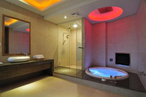 a bathroom with a tub and a shower and a tv at One + One Motel in Longtan
