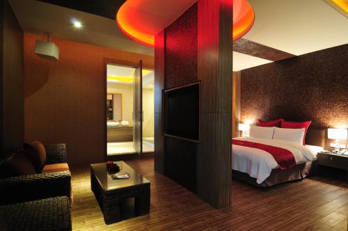 a hotel room with a bed and a television at One + One Motel in Longtan