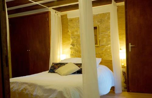 ヴィルフランシュ・ド・ルエルグにあるMas de la Combe Cachéeの石壁のベッドルーム1室(白いベッド1台付)