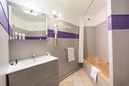 a bathroom with a sink and a tub at Les Pins Blancs en Provence in Le Muy