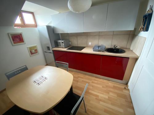 une petite cuisine avec une table et un évier dans l'établissement Gîte 65m2, 3 chambres, proxi commerces, à Mondelange, à Mondelange