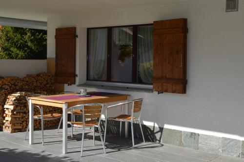 a table and chairs sitting next to a building at Tgèsa Parde in Sedrun