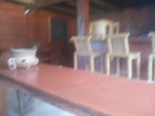 a table with chairs and a vase on it at Hostal Villas Mexico in San Juan del Sur