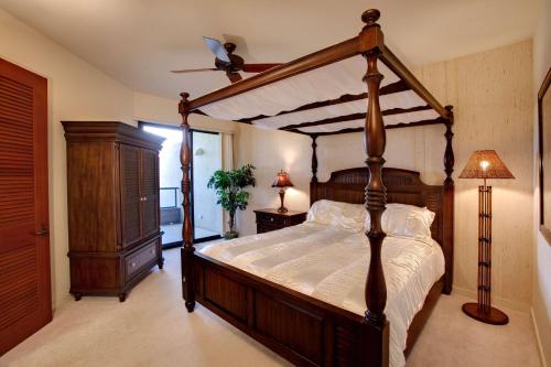 a bedroom with a canopy bed and a dresser at Mauna Lani Point in Waikoloa