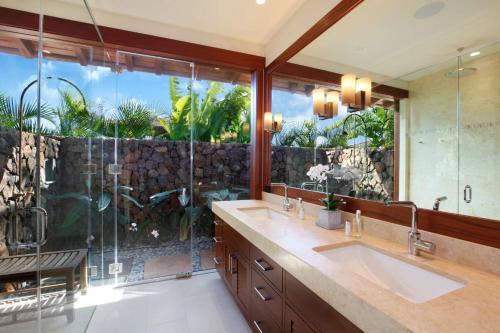 a bathroom with two sinks and a large window at The Lodge at Kukui’ula in Koloa