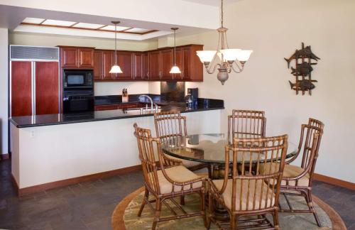 a kitchen with a table and chairs and a counter at Mauna Lani Point in Waikoloa