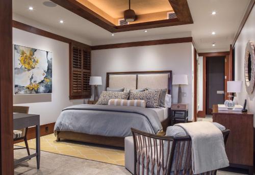 a bedroom with a king sized bed and a desk at The Lodge at Kukuiula - CoralTree Residence Collection in Koloa
