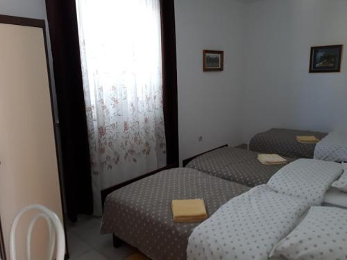 a room with three beds and a window at Apartments Roviš in Tar