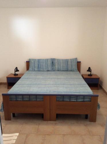 Ce lit se trouve dans un dortoir doté de 2 tables de chevet. dans l'établissement Appartamenti STELLA MARINA- Posto Rosso, à Alliste