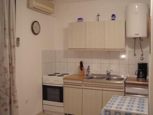 a small kitchen with a sink and a stove at Apartments Roviš in Tar