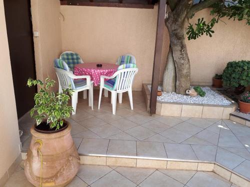 a patio with a table and chairs and a tree at Apartments Roviš in Tar