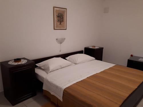 um quarto com uma cama grande e 2 mesas de cabeceira em Apartments Roviš em Tar