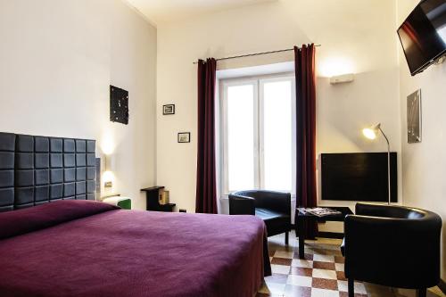 a bedroom with a bed and a tv and a window at Old Kitchen Vatican Suites in Rome