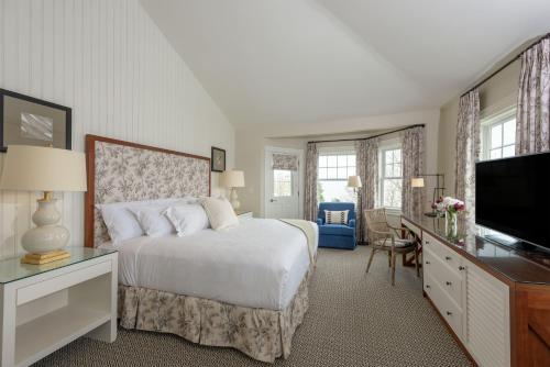 a bedroom with a bed and a flat screen tv at Harbor View Hotel in Edgartown