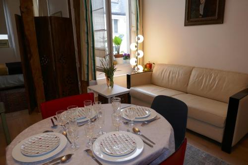 - une table avec des assiettes et des verres dans le salon dans l'établissement Appartment near Louvre, central, à Paris