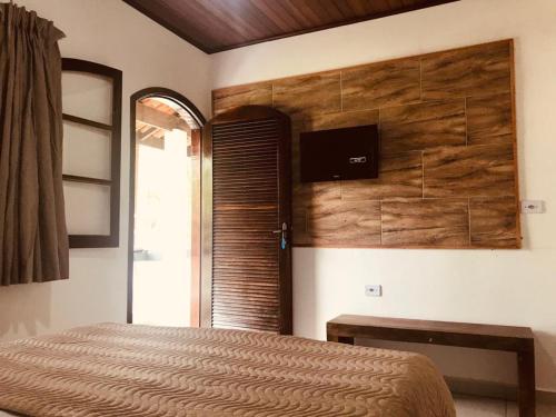 
a bedroom with a bed and a tv at Pousada Bem Viver in Ubatuba
