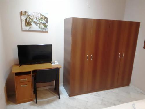 a desk with a television and a wooden cabinet at Thomas Palace Apartments in Sandanski