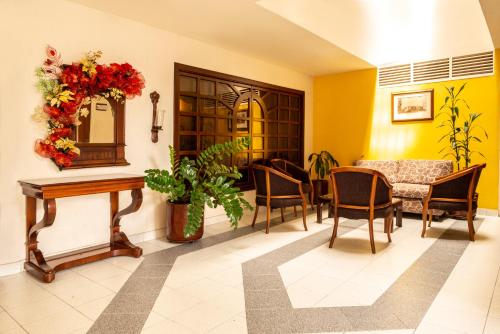 a waiting room with chairs and a table and a mirror at Hotel Principe in Tuluá