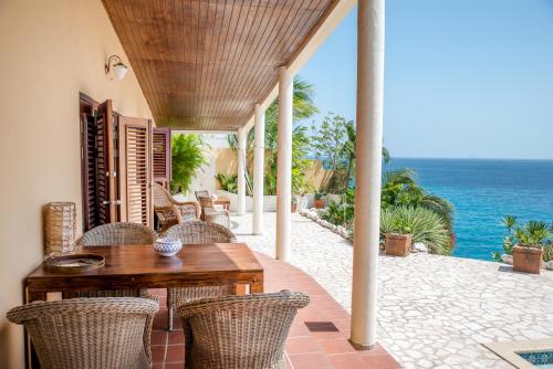 拉貢的住宿－鵜鶘別墅，一个带桌椅的庭院和大海