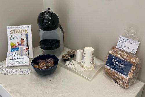 eine Theke mit einer Kaffeemaschine und einer Schachtel mit Lebensmitteln in der Unterkunft B&B Il Vicoletto in Castellammare di Stabia