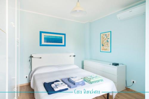 sypialnia z niebieskimi ścianami i łóżkiem z ręcznikami w obiekcie Casa Bianchera w mieście Monfalcone