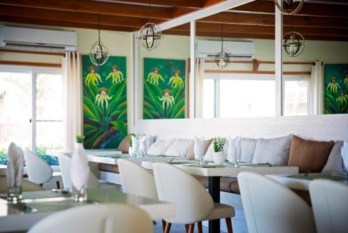 
a dining room filled with tables and chairs at Belizean Dreams Resort in Hopkins
