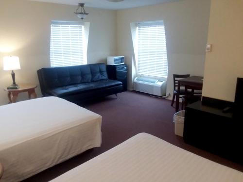 a hotel room with a bed and a couch at Walton Inn in Willard
