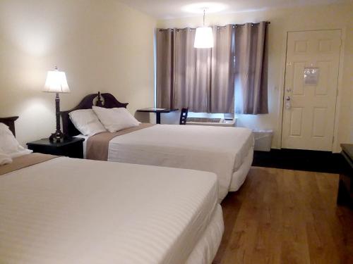 a hotel room with two beds and a window at Walton Inn in Willard