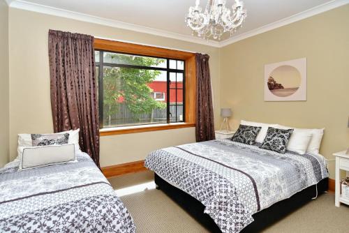 a bedroom with two beds and a window at Racecourse Villa - Classic 1935 Charm & Space in Christchurch