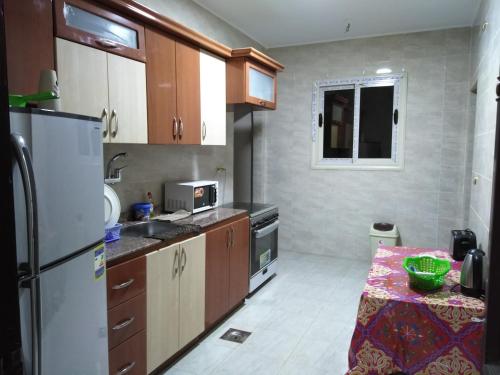 a kitchen with a refrigerator and a table in it at Pyramids View Apartment in Cairo
