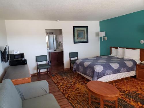 um quarto de hotel com uma cama e uma sala de estar em Americas Best Value Inn Greeley em Evans
