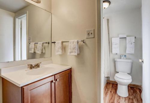 uma casa de banho com um lavatório, um WC e um espelho. em Americas Best Value Inn Greeley em Evans