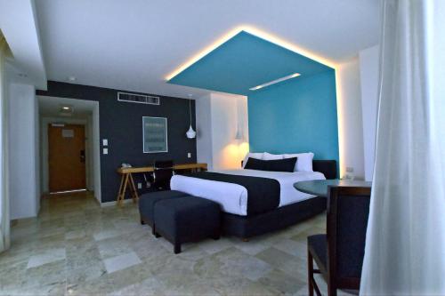 ein Schlafzimmer mit einem großen Bett und einer blauen Wand in der Unterkunft Rivoli Select Hotel in Veracruz