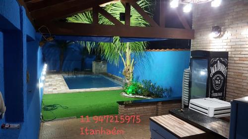 um quarto com uma piscina com uma palmeira em Casa de Praia com piscina - Itanhaém em Itanhaém