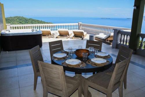 a table and chairs on a balcony with the ocean at 360 Splendor Del Pacifico Residences in Playa Flamingo