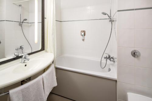 uma casa de banho com uma banheira, um lavatório e um chuveiro em ibis Southampton em Southampton