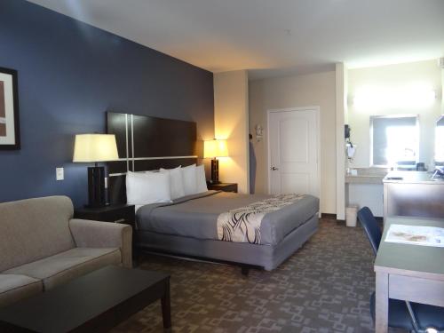 a hotel room with a bed and a couch at Regency Inn & Suites - Baytown in Baytown