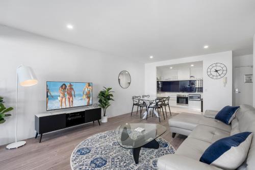 a white living room with a couch and a table at Circle on Cavill - Gclr in Gold Coast