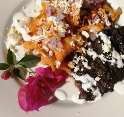 a white plate topped with a dessert with purple flowers at Margarita del Sol Hotel Costa Maya in Mahahual