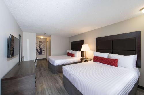 a hotel room with two beds with white and red pillows at SureStay Hotel by Best Western Castlegar in Castlegar