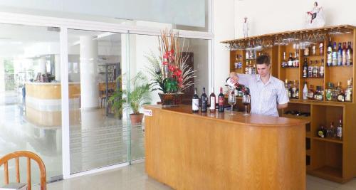 a man standing behind a bar with bottles of wine at Best Western Global Express in Veracruz
