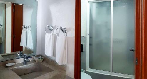 a bathroom with a glass shower and a sink at Best Western Global Express in Veracruz