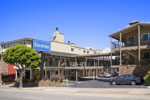 a hotel with a sign in front of a parking lot at Travelodge by Wyndham San Francisco Bay in San Francisco