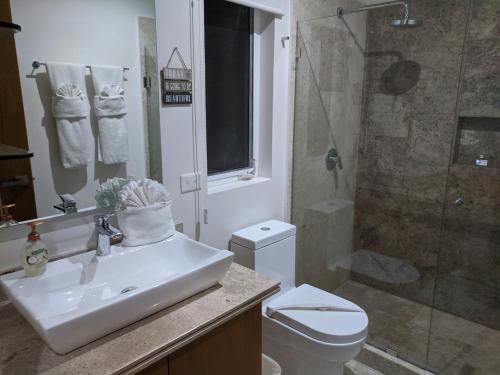a bathroom with a toilet and a sink and a shower at Bahia Principe & Golf Residences (Terrazas Condo) in Tulum