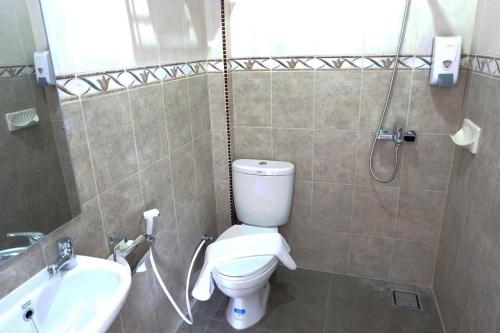 y baño con aseo, lavabo y ducha. en Cordex Oase Pekanbaru en Pekanbaru