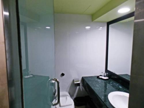 a bathroom with a sink, toilet and shower stall at Harbour View Hotel in Kuching