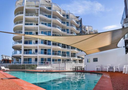 a swimming pool in front of a large apartment building at Regency on the Beach in Gold Coast