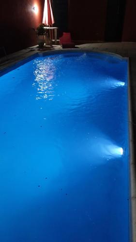 una gran piscina azul en una habitación oscura en COMPLEJO DOÑA OLGA en La Rioja